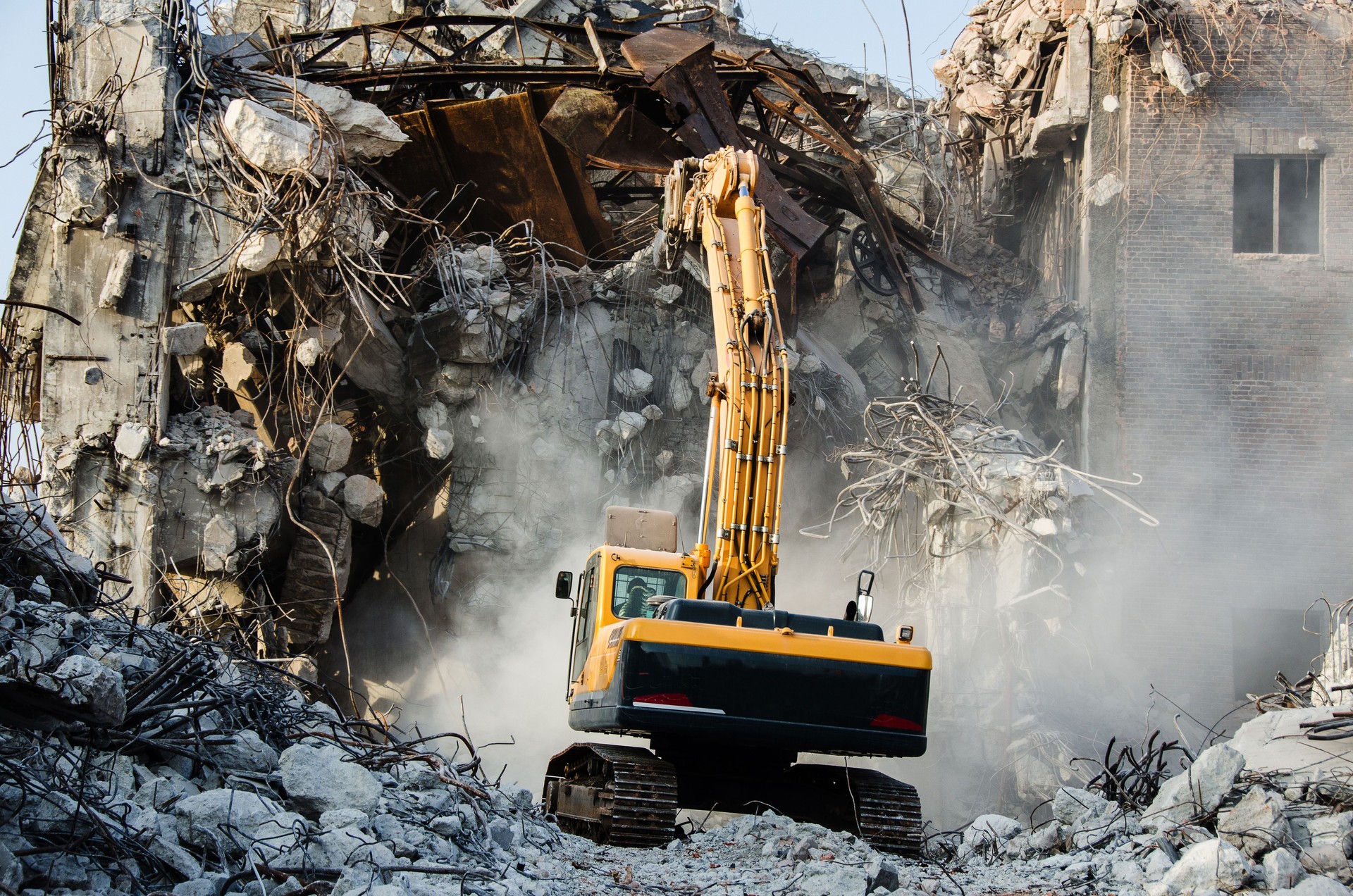 Excavator working at the demolition of an old industrial buildin
